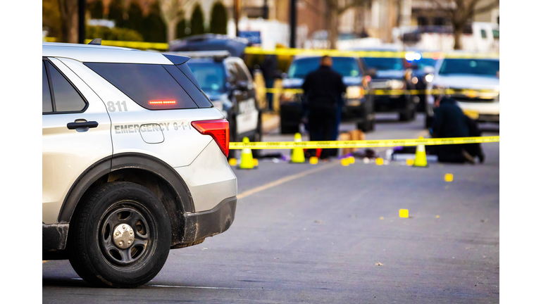 Police car with emergency lights on road with caution tape