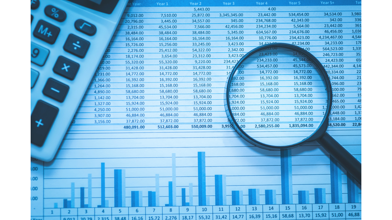 Spreadsheet bank accounts accounting with calculator and magnifying glass.