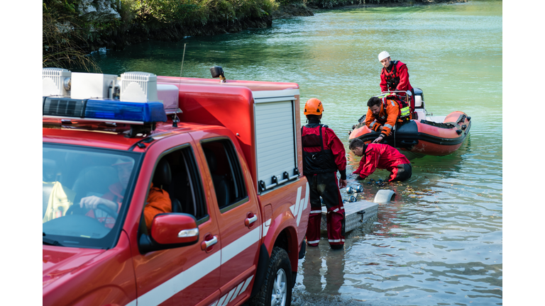 Dam construction on the river - rescue operation with a boat, oil spill