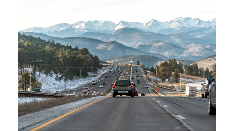 Colorado interstate i70 road in Denver Golden with exit sign and traffic jam from snow capped mountains ski season
