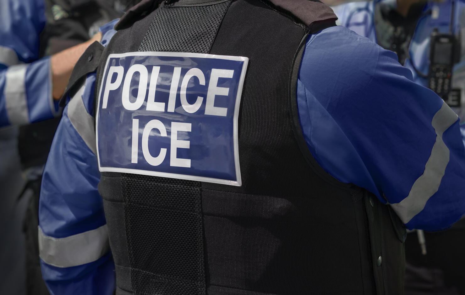 Ice Police agents - Immigration and Customs Enforcement. Close-up of POLICE ICE marking on the back of worn by a trio of DHS police officers at the scene of an incident.