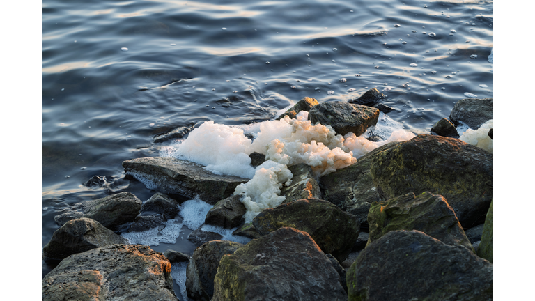 Sea foam on a rocky shore