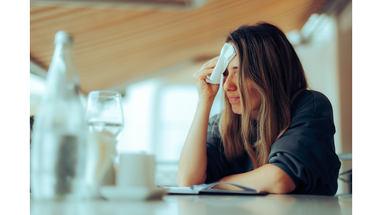 Woman Wiping Sweaty Forehead Using a Napkin
