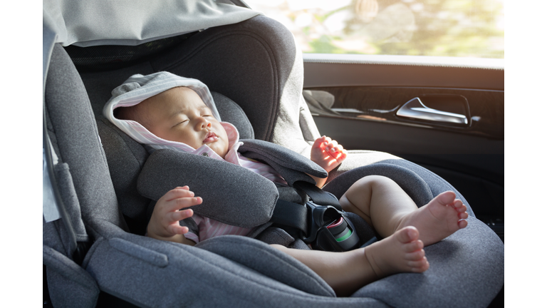 Close Up Asian cute newborn baby sleeping in modern car seat.