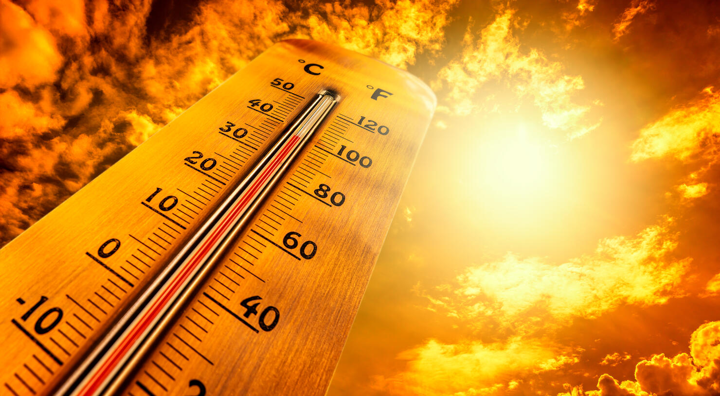 Thermometer showing tropical heat and sky with hot sun rays in Celsius and Fahrenheit