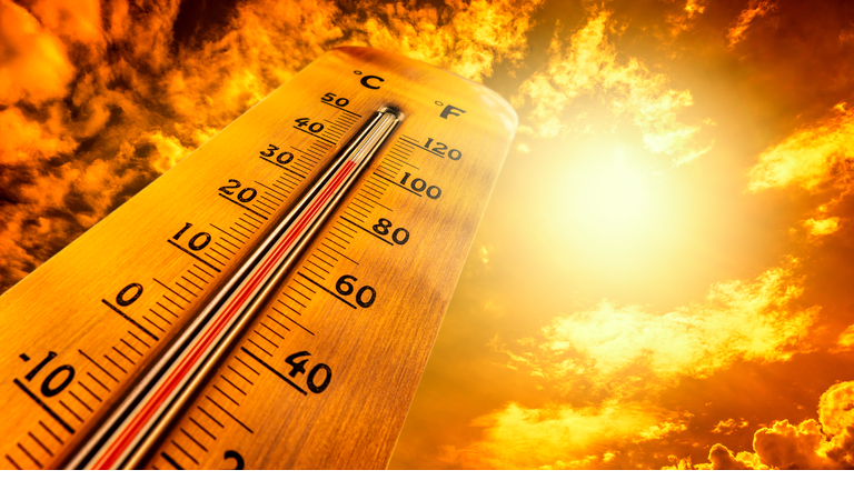 Thermometer showing tropical heat and sky with hot sun rays in Celsius and Fahrenheit