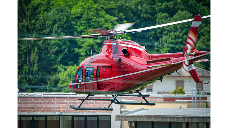 red helicopter in flight