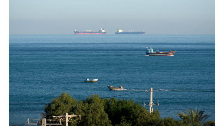 Fishing and cargo container ships sailing in the Strait of Hormuz by Qeshm island, Persian Gulf, Iran