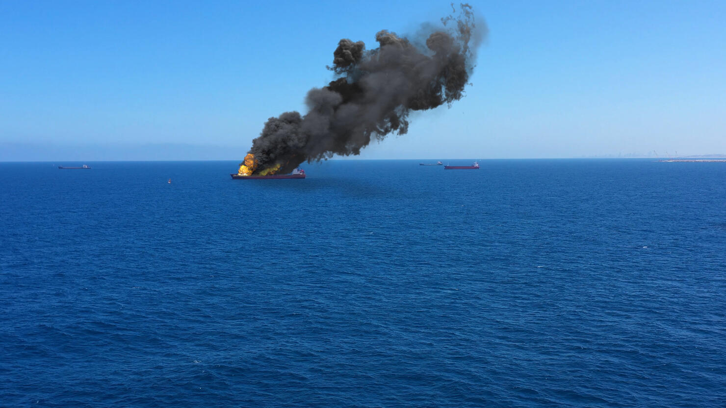 Cargo ship burning on fire with large scale smoke-Aerial