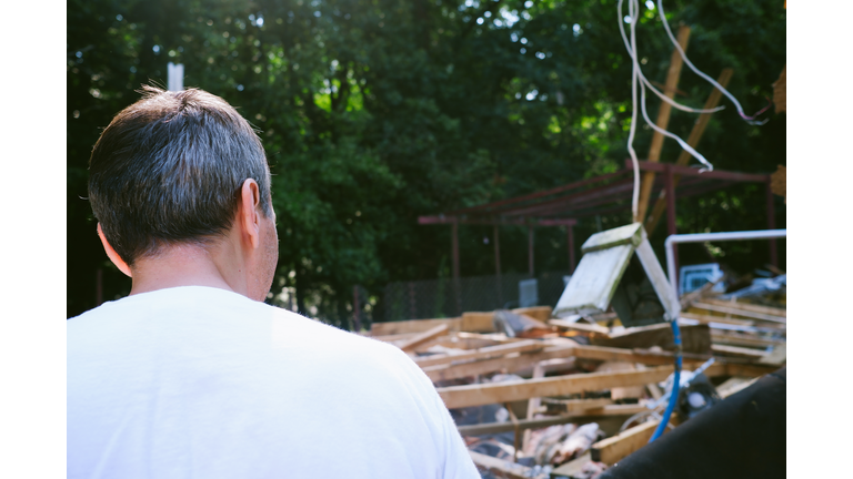 Man Views Rubble From Partial Home Demolition