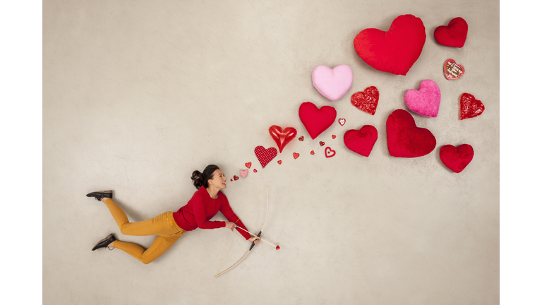 Woman with bow and arrow and hearts around