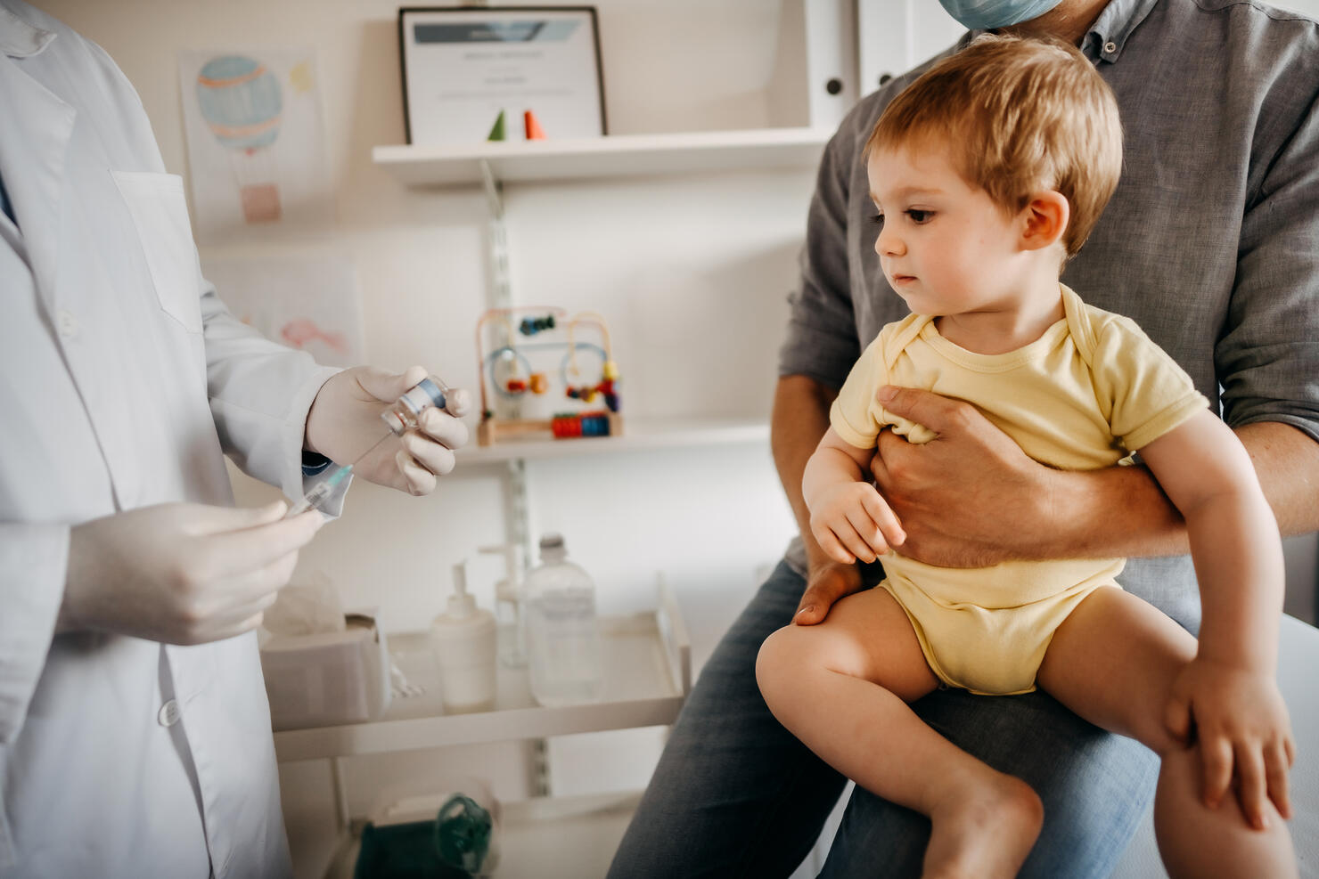 Doctor preparing vaccine for baby boy