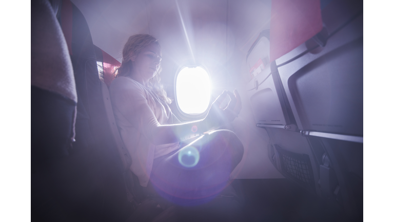 Young woman practicing yoga in the plane.