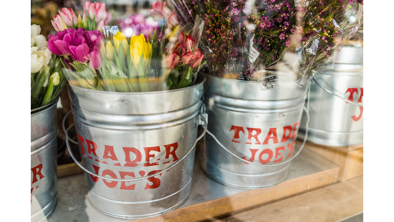 Buckets of flowers with Trader Joe's signs viewed from outside of store
