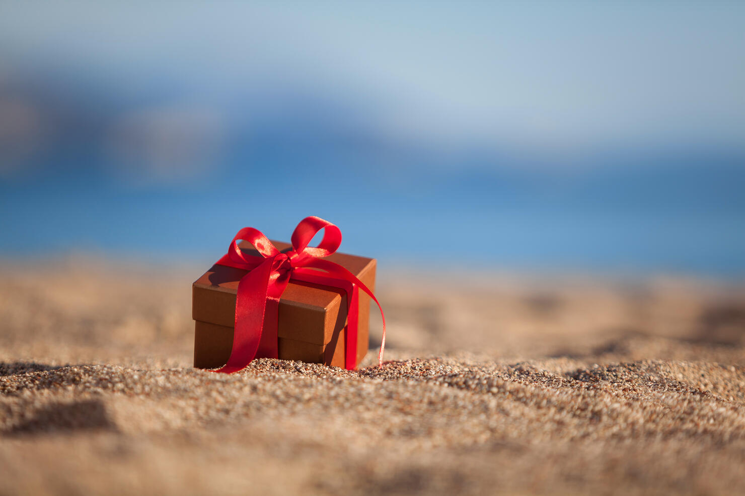 Terracotta color gift box ona beach