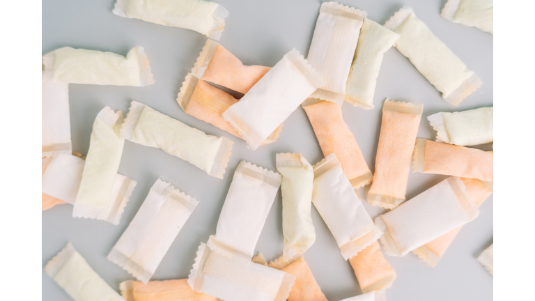 Lots of snus bags with fruit and mint flavors on a light background