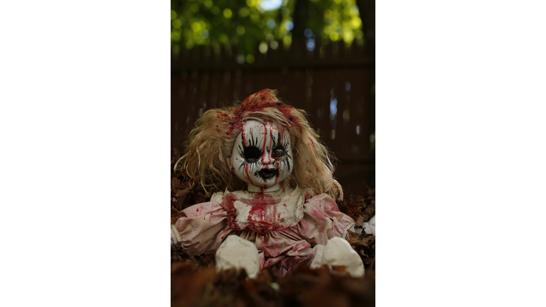 Vertical closeup shot of a scary Annabelle doll on the grass