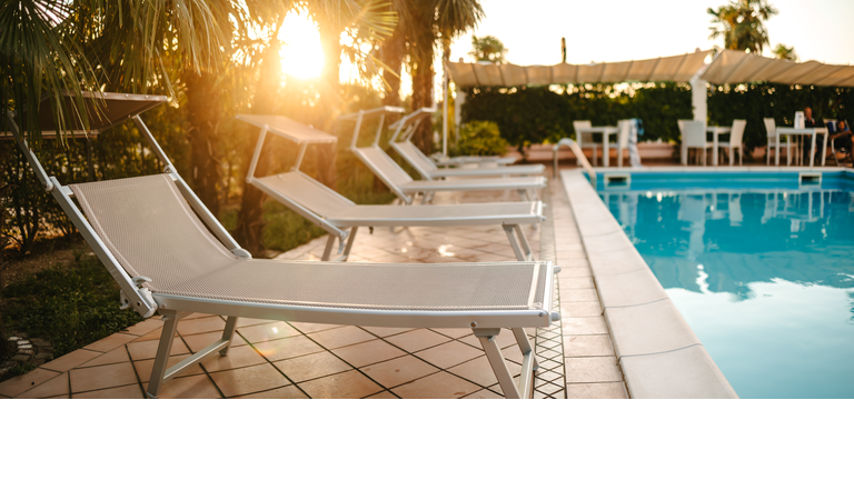 Sunbeds by the pool at sunset