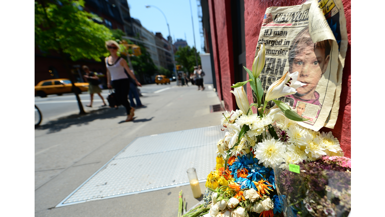 People walk past a street shrine to six-