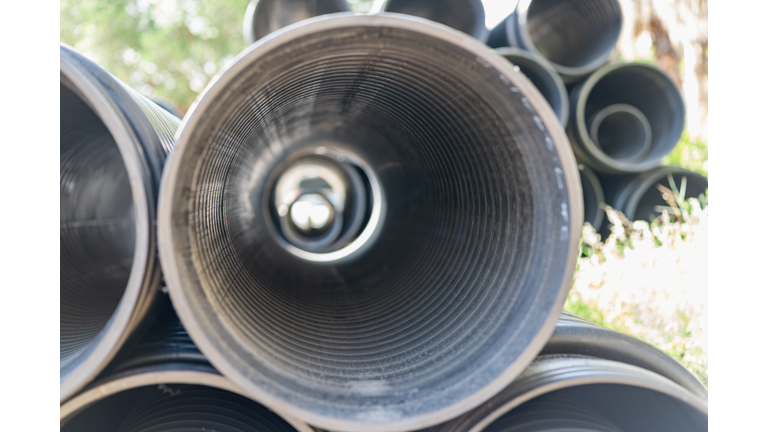 Stacked plastic sewer pipes on a construction site