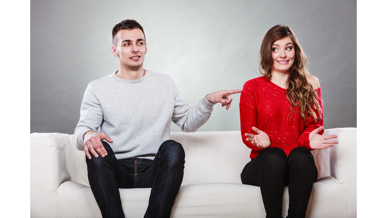 Shy woman and man sitting on sofa. First date.