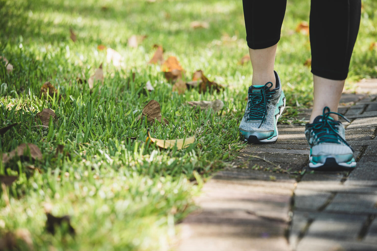 asian woman running in a park, closeup on the shoes