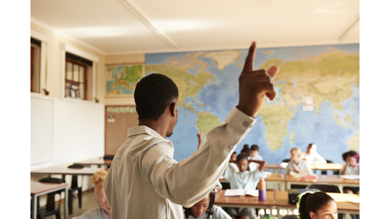 Teacher pointing and teaching group of students