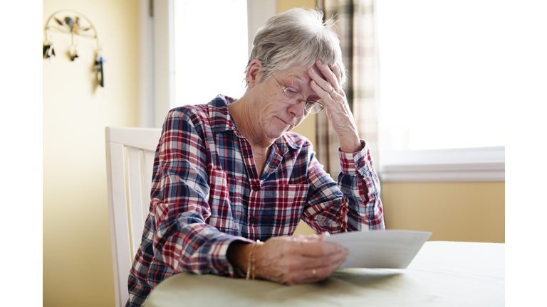 Elderly woman worry about bill notice at home