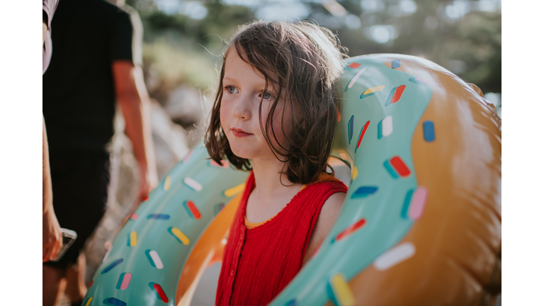 Portrait of a child on vacation in a hot country, holding a large rubber ring