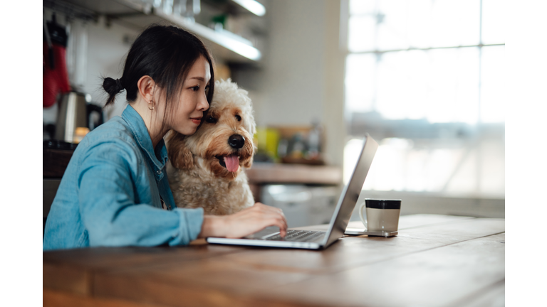 Young woman working from home with her dog