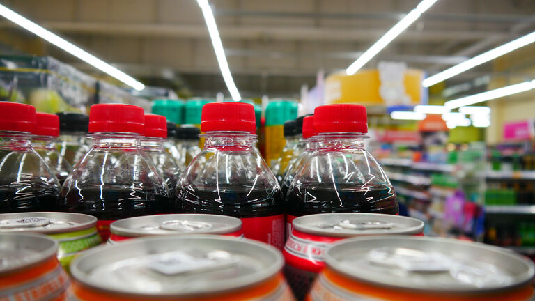 Close-up of many plastic cola bottles in a supermarket