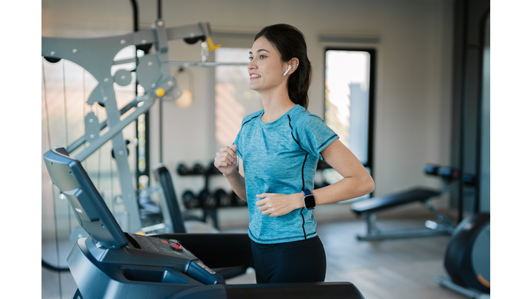 Young woman jogging on the treadmill at the gym.