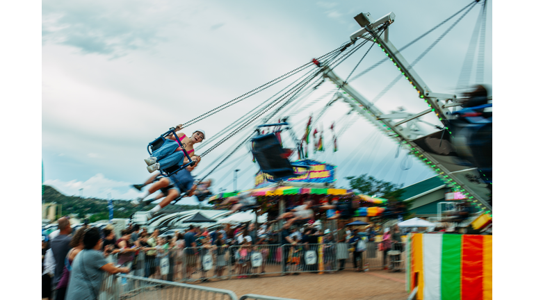 Scared teen girl on swing at carnival