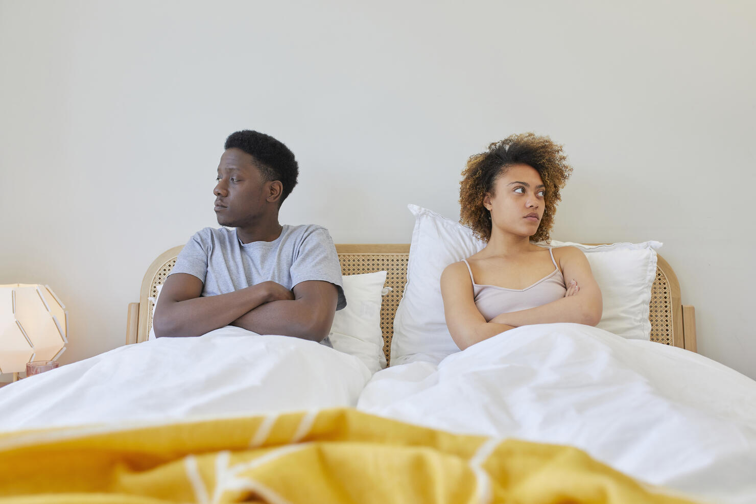 Young couple sitting next to each other in bed.