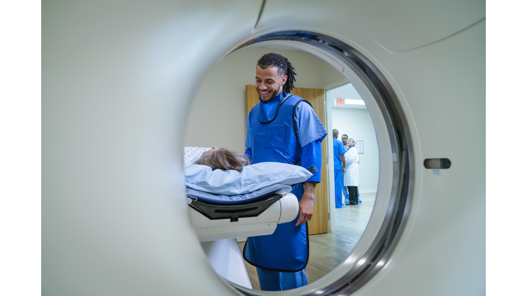 Technician talking to patient near scanner