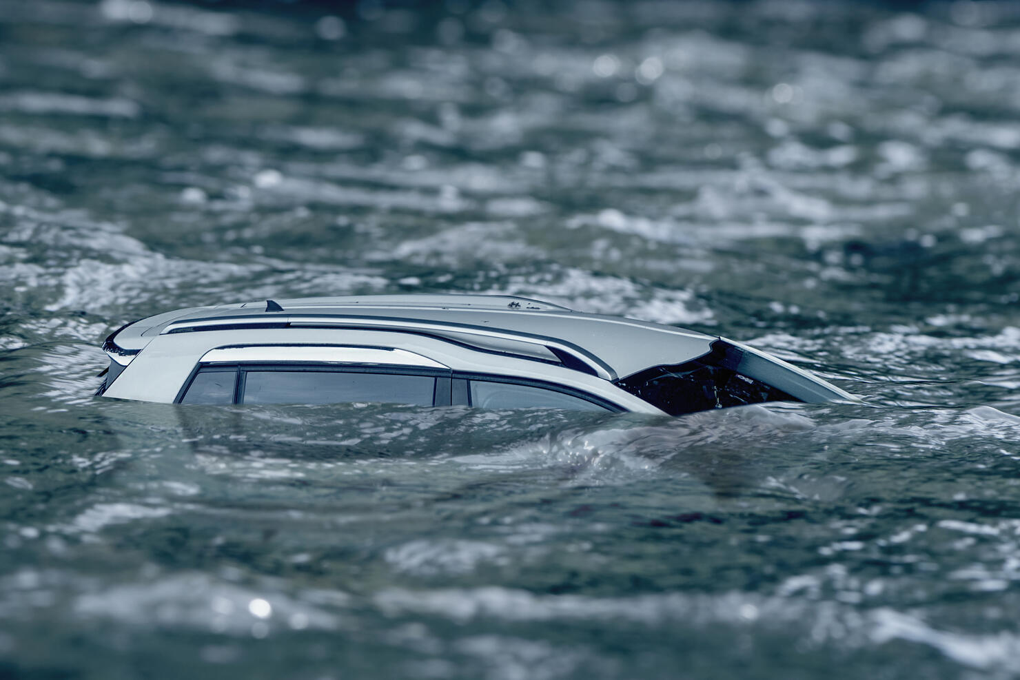 Flooded car floating in the water flow, flooding after the rains, the breach of the dam in Ukraine.