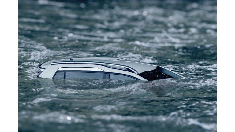 Flooded car floating in the water flow, flooding after the rains, the breach of the dam in Ukraine.