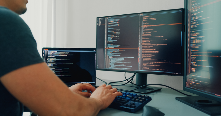 Closeup young man software developers using computer to write code application program for AI technology development at desk with multiple screens work at home office. Programmer development.