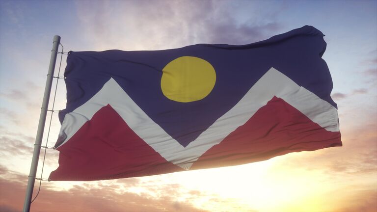Denver city of Colorado flag waving in the wind, sky and sun background. 3d rendering