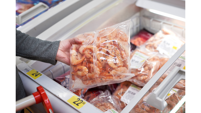 Packing of frozen shrimp in hand at grocery store