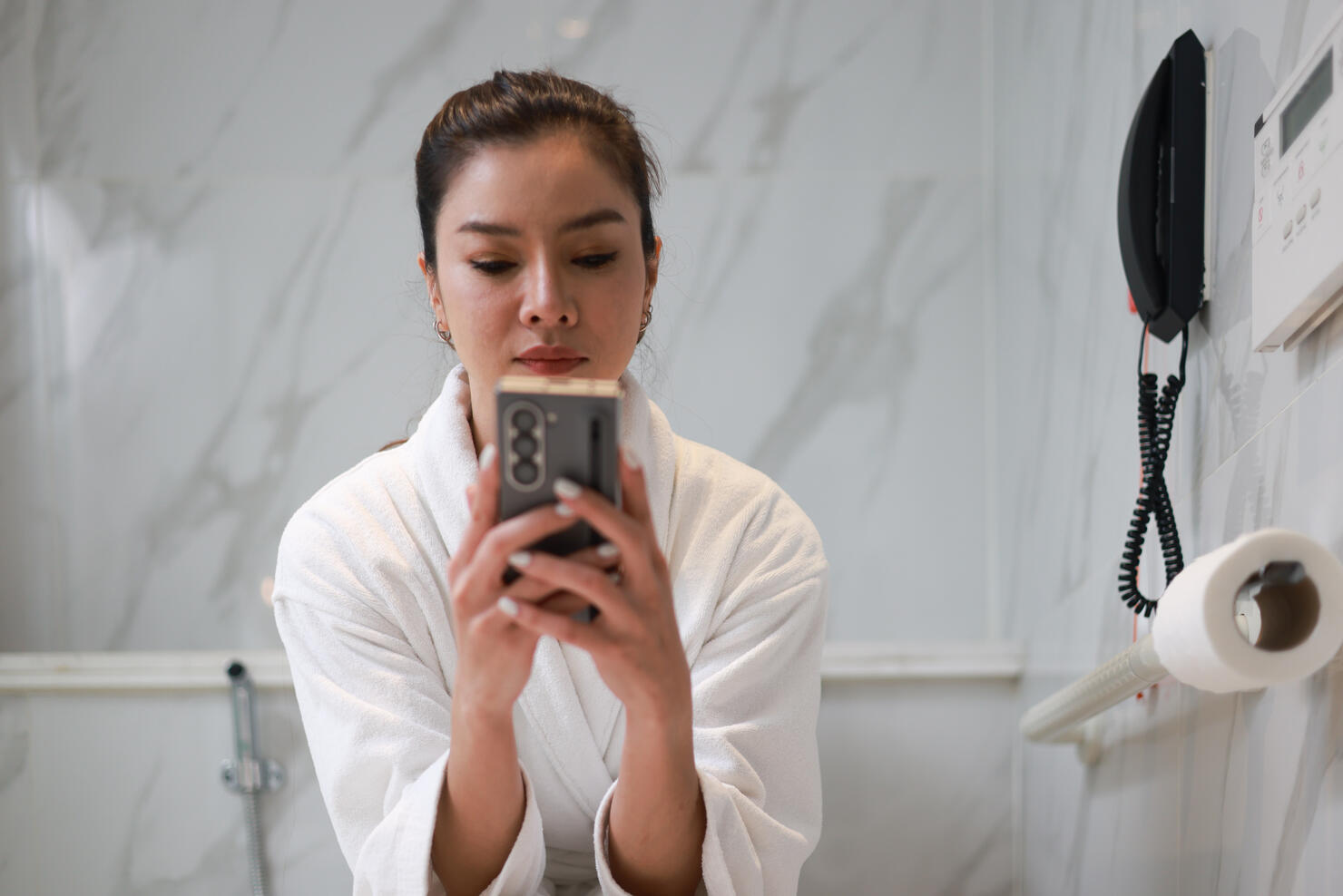 Asia Woman using mobile phone on toilet bowl in restroom, Home living lifestyle ,Daily routine. Lifestyle and technology