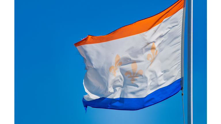 New Orleans flag on a blue sky background.