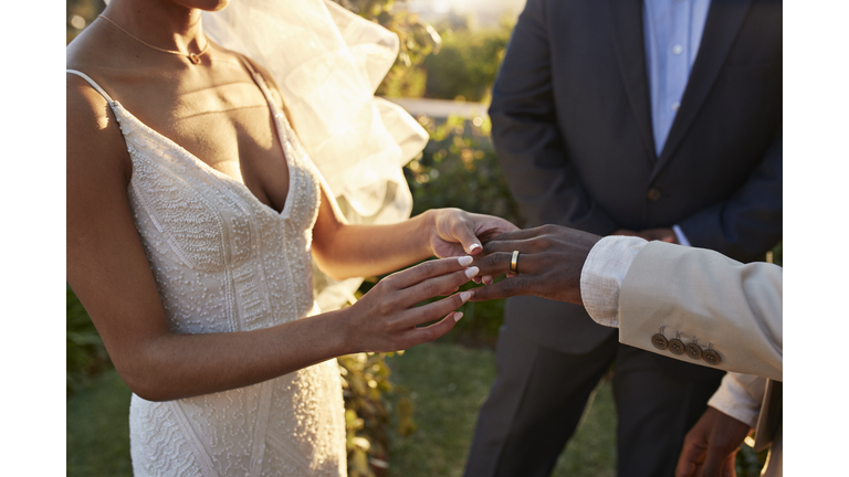 Young bride exchanging wedding ring with groom