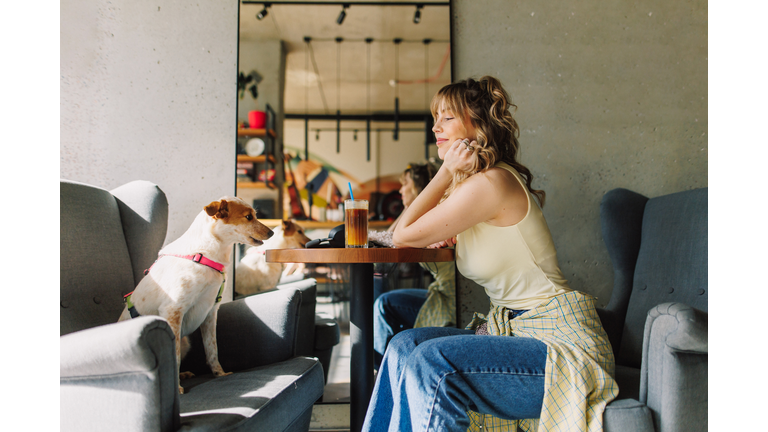 Beautiful Woman Sitting in a Café with Her Dog