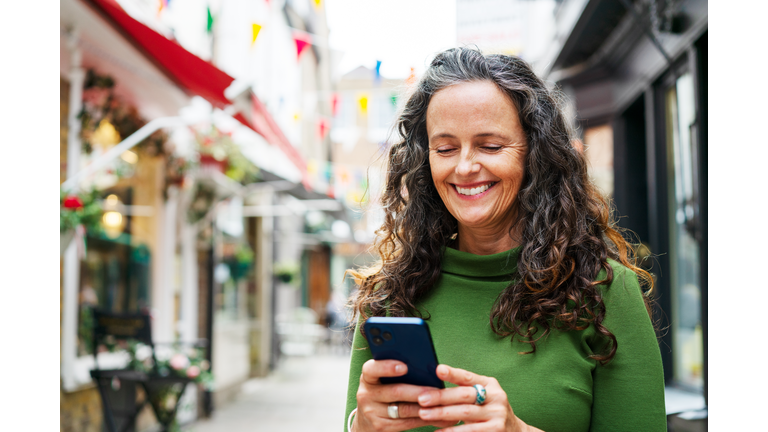 Woman using smart phone in town