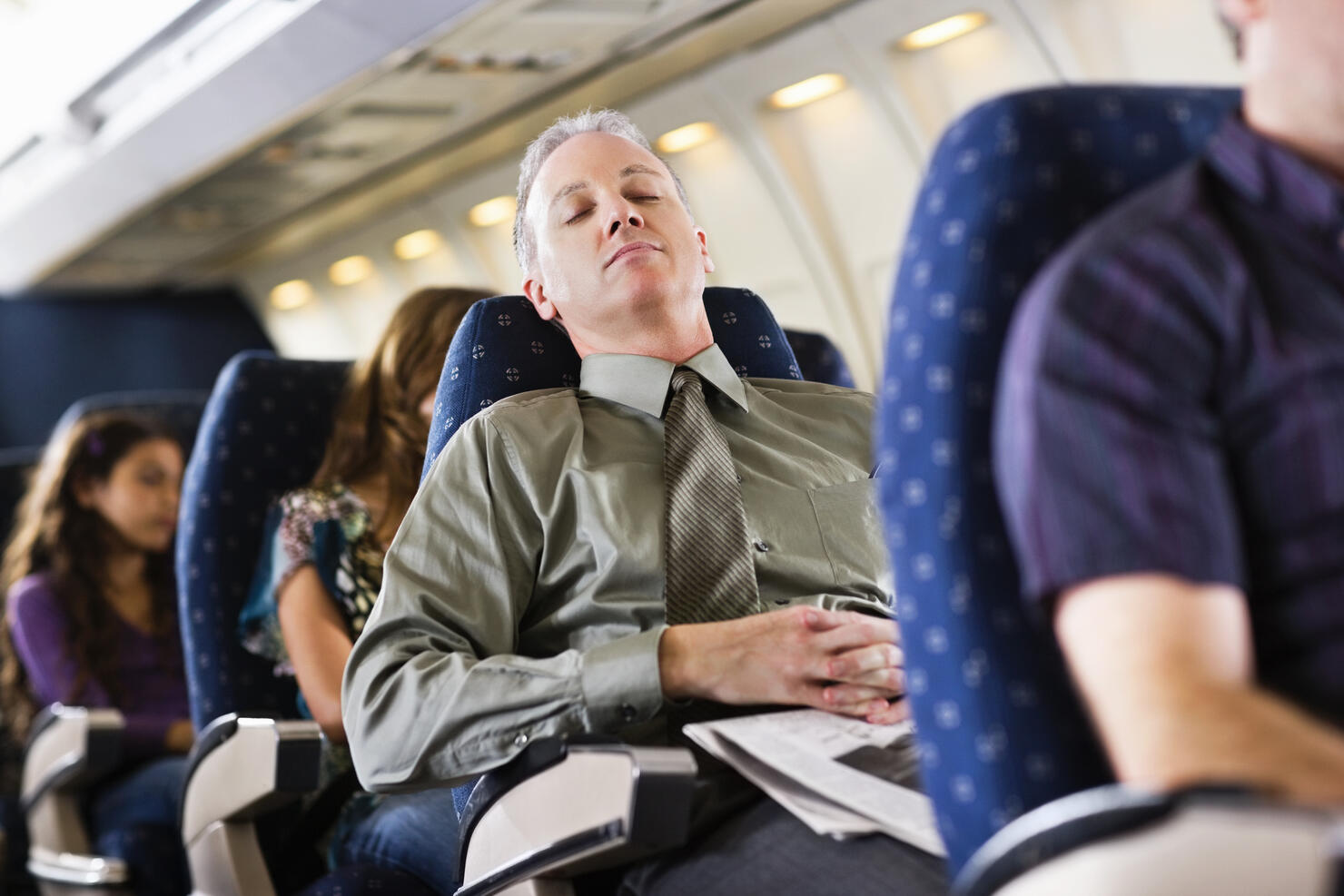 business man sleeping on airplane