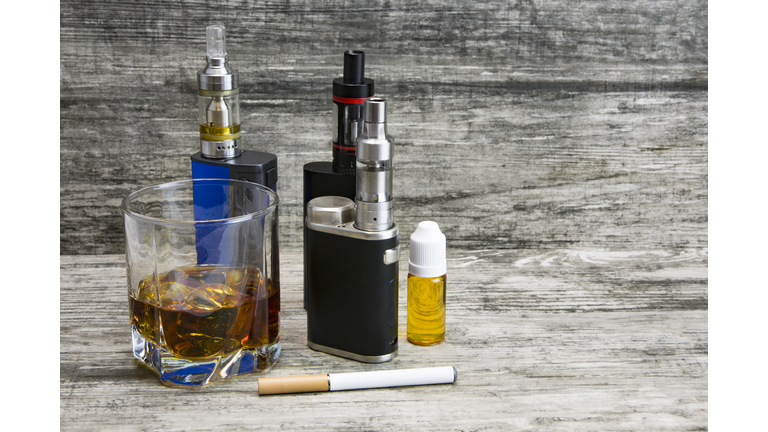Whiskey in a glass with an e-cigarette
