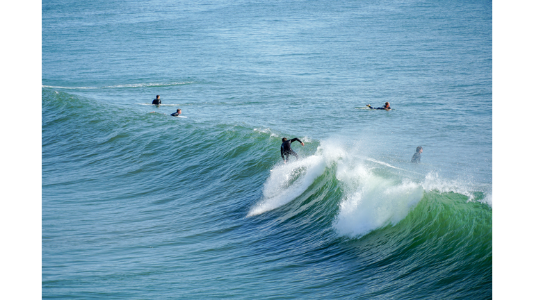 Male surfers enjoying the big waves in Oceanside in North San Diego, California, USA.
