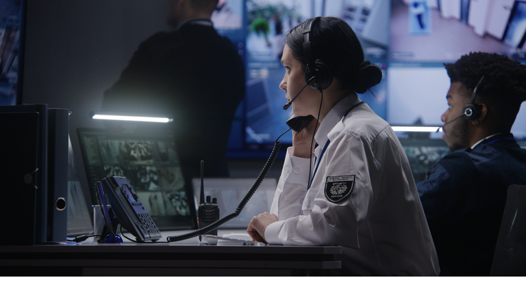 Female officer works on computer in police monitoring center