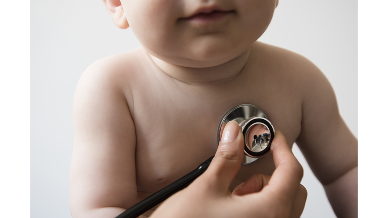 Doctor listening to chest of baby boy with stethoscope
